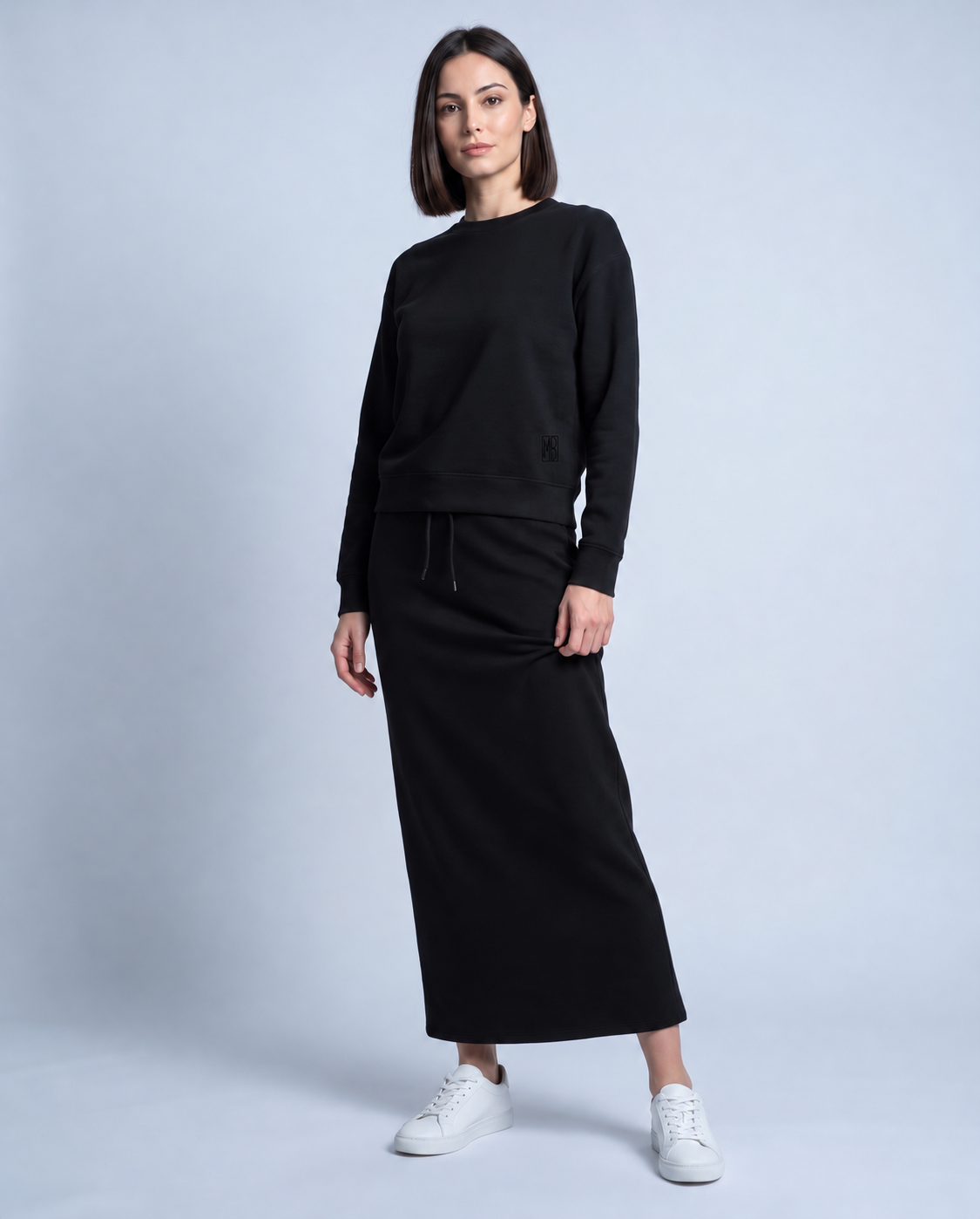 Black crewneck sweatshirt with long sleeves, ribbed cuffs, and monogram logo detail