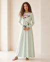Model wearing a mint green long-sleeve nightgown with a pink lily print and long skirt