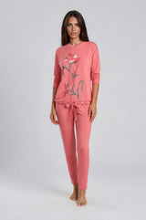Coral pink floral pajama set with long-sleeve top and drawstring pants, worn by a model
