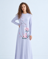 Model wearing a light blue floral nightgown with long sleeves and a flowing ankle-length skirt