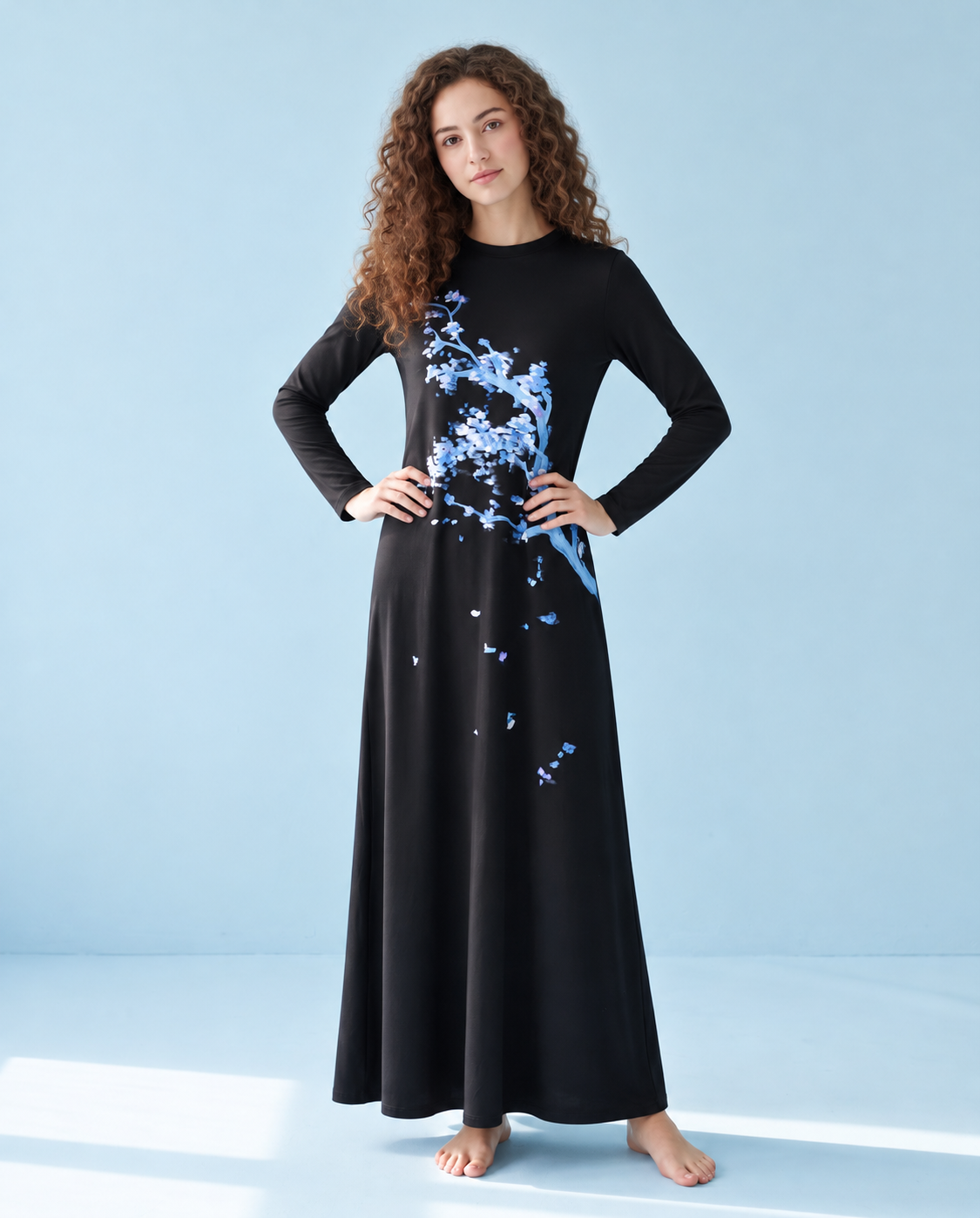 Model wearing a black floor-length nightgown with long sleeves and blue blossom print