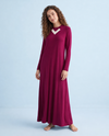 Model wearing a wine-colored long-sleeve nursing nightgown with a white V-neck accent and flowing skirt.