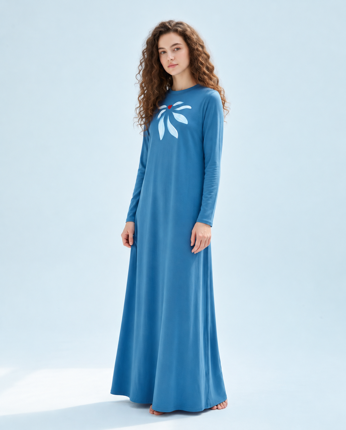 Blue long-sleeve nightgown with a white floral chest motif and red center, shown worn full length.