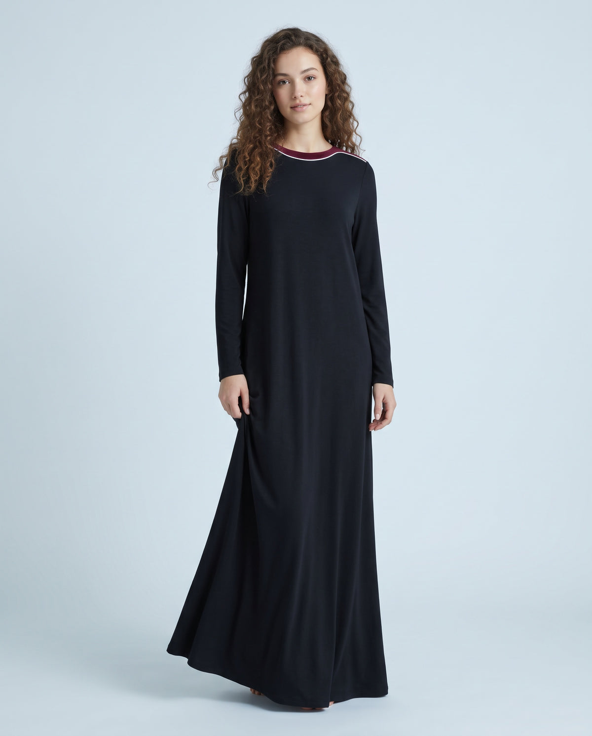 Black long-sleeve maxi nightgown with contrasting velvet neckline trim, shown on a model