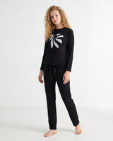 Black two-piece pajama set worn with a white bow print top and matching drawstring pants.