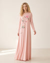 Model wearing a floor-length pink nightgown with long sleeves and a floral branch print