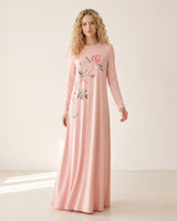 Model wearing a floor-length pink nightgown with long sleeves and a floral branch print