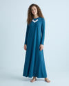 Model wearing a blue nursing nightgown with long sleeves and white V-neck trim