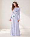 Model wearing a floor-length blue nightgown with long sleeves and floral branch print