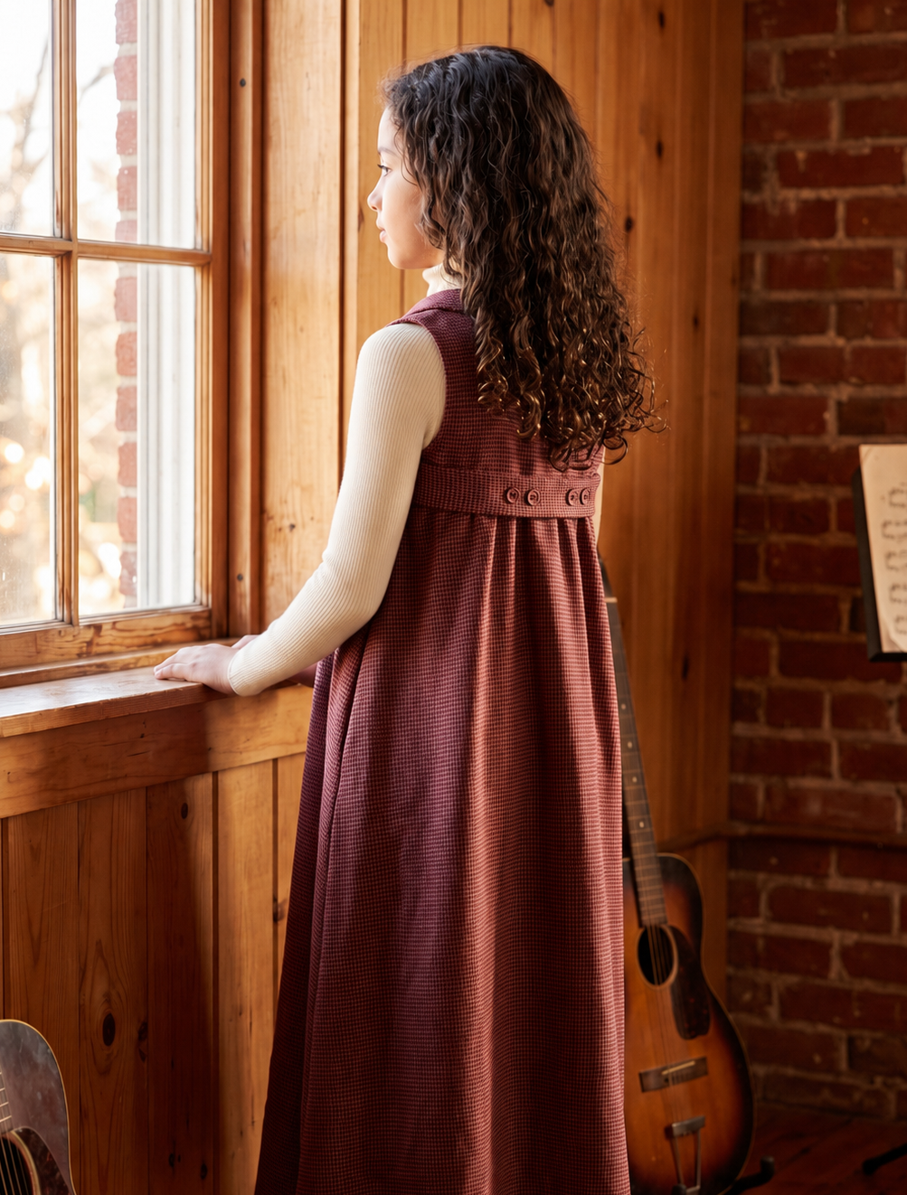Coffee colored child's sleeveless maxi dress in textured fabric features notched lapel collar, button placket , empire cut waist and back button tab.